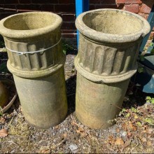 Pair of buff round chimney pots with decorative channeling